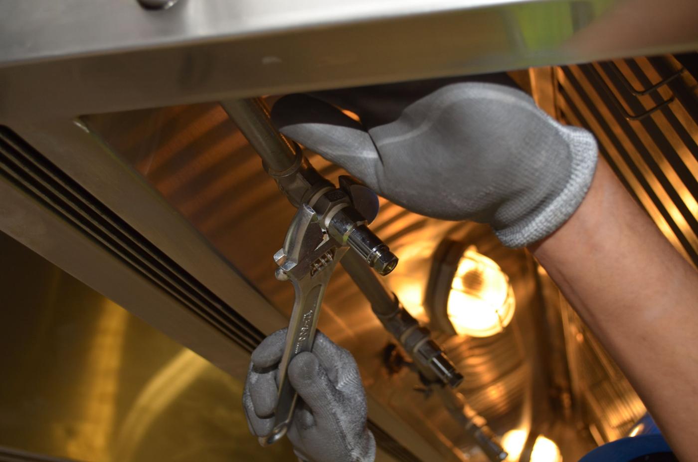 Technician tightening a fitting with a wrench